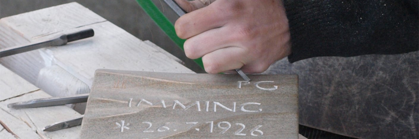 Steinmetz haut Schrift in ein Grabzeichen