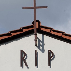Kreuz und Schrift RIP am Giebel einer Trauerhalle